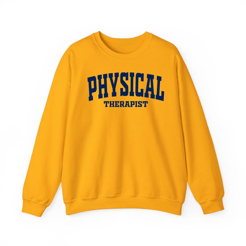 K&ouml;nnte beinhalten: Senfgelbes Sweatshirt mit dem Aufdruck "PHYSICAL THERAPIST" in marineblauen Gro&szlig;buchstaben. Das Sweatshirt hat einen Rundhalsausschnitt und lange &Auml;rmel. Der Text ist mittig auf der Brust platziert.