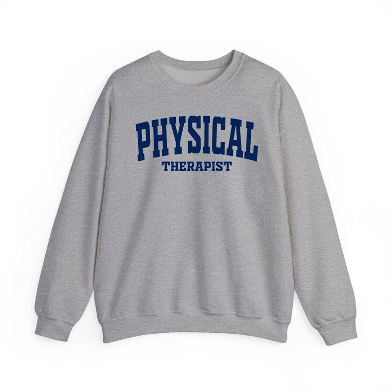 K&ouml;nnte beinhalten: Ein hellgraues Sweatshirt mit dem navyblauen Aufdruck "PHYSICAL THERAPIST" auf der Brust. Das Sweatshirt hat einen Rundhalsausschnitt und lange &Auml;rmel, geeignet f&uuml;r den t&auml;glichen Gebrauch.