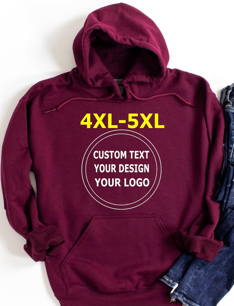 May include: A maroon hooded sweatshirt with a front pocket and drawstring hood. The text "4XL-5XL" is in yellow at the top, and a white circle with the words "CUSTOM TEXT YOUR DESIGN YOUR LOGO" is in the center.