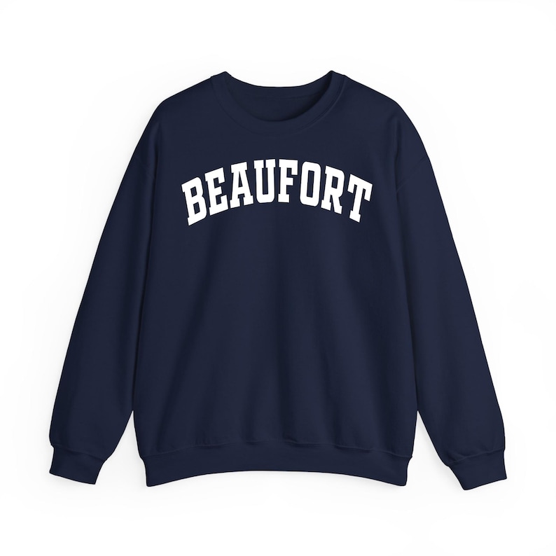 May include: A navy blue sweatshirt with the word "BEAUFORT" printed in large, white, arched letters across the chest. The sweatshirt has a crew neck and long sleeves, suitable for cooler weather.