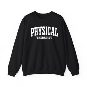 K&ouml;nnte beinhalten: Schwarzes Sweatshirt mit Rundhalsausschnitt und dem Aufdruck "PHYSICAL THERAPIST" in wei&szlig;en Blockbuchstaben. Das Wort "PHYSICAL" steht &uuml;ber "THERAPIST". Ein l&auml;ssiges, bequemes Oberteil f&uuml;r Physiotherapeuten.