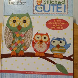 May include: A book titled "Stitched So Cute!" with a cover featuring three colorful owls on a branch. The book contains 53 embroidery projects for family and friends.