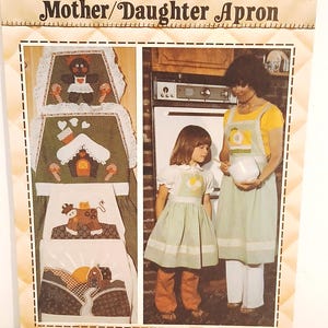 May include: A vintage "Patch Press" pattern for a Mother/Daughter apron. The package features a picture of the aprons, with a farmhouse and a girl and woman wearing aprons. The text reads "Mother/Daughter Apron".