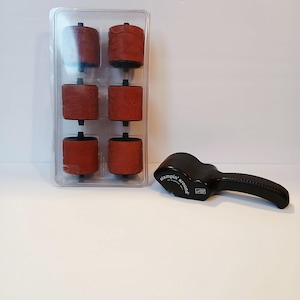 May include: A set of six red rubber stamp rollers in a clear plastic case, with a black handle stamp tool. The handle is black and has the words "stampin' around" printed on it.