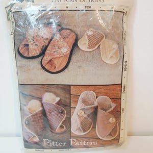 May include: A package of "Favorite Things" pattern designs featuring various slipper styles. The designs include open-toe sandals with floral fabric, closed-toe slippers with plaid and solid fabrics, and button closures. The package is in a clear plastic bag.