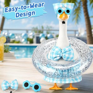 May include: A white goose figurine wearing a light blue and white gingham bikini top, a matching skirt, a headpiece, and flower-shaped sunglasses. A clear, glitter-filled inflatable swim ring surrounds the goose. Text reads Easy-to-Wear Design.