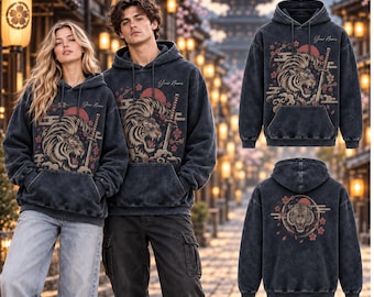 Pode incluir: Um moletom com capuz cinza-carvão com lavagem ácida, apresentando um gráfico de um tigre rugindo, uma espada katana e flores de cerejeira. A frente inclui o texto Your Name, enquanto as costas exibem um emblema circular de tigre.