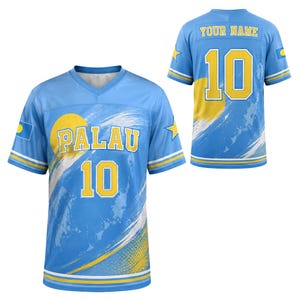 May include: A light blue sports jersey featuring a yellow sun graphic, the text PALAU, and the number 10 on the front. The back displays the text YOUR NAME and the number 10. Both sides include yellow star accents and the Palau flag on the sleeves.