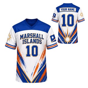 May include: A V-neck sports jersey featuring the text MARSHALL ISLANDS and the number 10 in blue and orange. The design includes blue and orange brushstroke patterns on a white background, with the Marshall Islands flag on the sleeves.