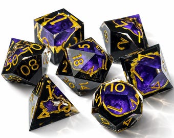 May include: A set of seven polyhedral dice made of clear resin with deep purple inclusions and gold-colored flakes. Each die features sharp edges and engraved numbers filled with gold paint, including a d20, d12, d10, d8, d6, d4, and a percentile die.
