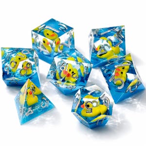 May include: A set of seven polyhedral dice made of clear blue resin, each containing a miniature yellow rubber duck. The dice feature sharp edges and silver-colored numbers engraved on the faces, creating a water-like appearance.