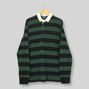 May include: A long-sleeve rugby shirt featuring horizontal black and dark green stripes. The shirt has a white collar, a button-up placket, and a small red embroidered logo on the left chest. The interior label reads Polo by Ralph Lauren.