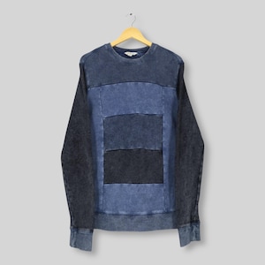 May include: A long-sleeve crewneck sweatshirt featuring a color-blocked design with horizontal panels in varying shades of blue. The garment has a washed, distressed texture throughout, with dark blue sleeves and a ribbed collar, cuffs, and hem.
