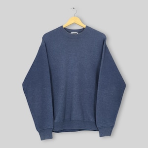 Op de afbeelding: Een effen marineblauw sweatshirt met ronde hals, lange mouwen en geribbelde boorden. Het kledingstuk heeft een eenvoudig ontwerp met een klassieke ronde halslijn en hangt aan een houten kledinghanger tegen een neutrale grijze achtergrond.