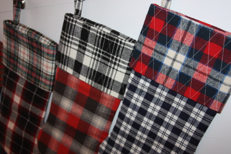 May include: Four Christmas stockings made from plaid fabric in red, black, white, and blue.