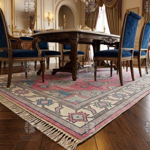 K&ouml;nnte beinhalten: Ein Esszimmer mit einem gro&szlig;en, verzierten Tisch und blauen Samtst&uuml;hlen. Ein gemusterter Teppich in Rosa-, Blau- und Cremet&ouml;nen bedeckt den Boden. &Uuml;ber dem Tisch h&auml;ngt ein Kronleuchter, und ein Spiegel ist sichtbar.