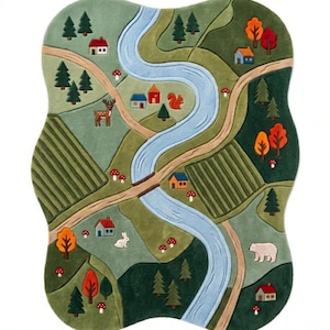 May include: A shaped area rug featuring a colorful landscape illustration with a winding blue river, tan dirt paths, green fields, and dark green forests. The scene includes small houses, red and orange trees, mushrooms, a deer, a squirrel, a rabbit, and a bear.