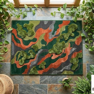 May include: A rectangular rug with an abstract design in shades of green, orange, and gray. The rug features raised, textured areas that create a three-dimensional effect. The rug is surrounded by lush greenery, including ferns and potted plants.