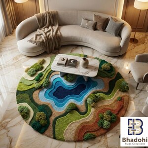 May include: A round, landscape-themed rug with a lake and hills design. The rug features shades of green, blue, and brown, with textured elements to mimic trees and terrain. A white marble coffee table sits atop the rug, with a beige sofa in the background.