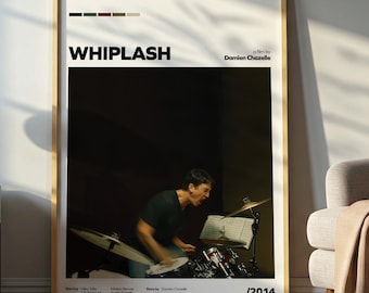 May include: A framed poster for the movie "Whiplash" featuring a drummer playing. The poster has a wooden frame and the movie title is in bold, black letters. The poster also includes the director's name and the year 2014.