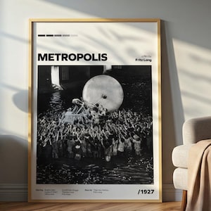 以下が含まれることがあります： 1927年の映画「メトロポリス」の額入り白黒ポスター。ポスターには、人々の群衆と大きな円形の物体が描かれています。ポスターは、サイドテーブル、ランプ、椅子のある部屋にあります。