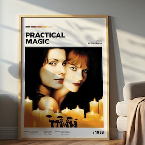 Könnte beinhalten: Ein gerahmtes Filmplakat für "Practical Magic" mit den Gesichtern zweier Frauen und brennenden Kerzen im Vordergrund. Das Poster hat einen Holzrahmen und wird in einem Raum mit Lampe, Beistelltisch und Stuhl ausgestellt.