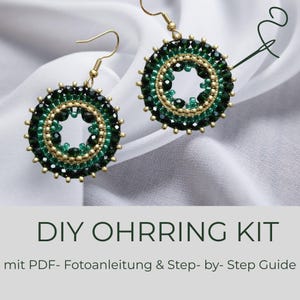 Pode incluir: Um par de brincos feitos à mão com um design circular. Os brincos apresentam uma armação de metal dourado, com um anel de pequenas contas verde escuro e um anel de contas douradas. O texto "DIY OHRRING KIT" está na parte inferior da imagem.