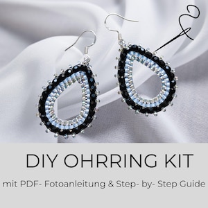 Könnte beinhalten: Ein Paar tropfenförmige Perlenohrringe mit schwarzen und hellblauen Perlen sowie silberfarbenen Haken. Der Text DIY OHRRING KIT mit PDF- Fotoanleitung & Step- by- Step Guide steht unter den Ohrringen auf einem hellgrauen Hintergrund.