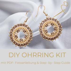 May include: A pair of circular beaded earrings featuring gold-tone hooks, brown and cream-colored beads, and a central open design. The text below reads DIY OHRRING KIT mit PDF- Fotoanleitung & Step- by- Step Guide.