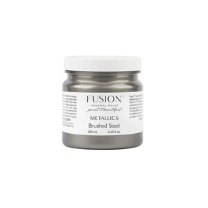 May include: A round jar of Fusion Mineral Paint in the colour Brushed Steel. The jar is silver with a white lid and the text "Fusion Mineral Paint paint it beautiful" and "Metallics Brushed Steel" is printed on the label. The jar contains 8.45 fluid ounces or 250 millilitres of paint.