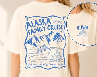 May include: An ivory t-shirt featuring a blue graphic on the back with mountains, a cruise ship, a whale tail, and text reading Alaska Family Cruise, Johnson Family, August 2026. The front chest area displays the name Olivia and a cruise ship.