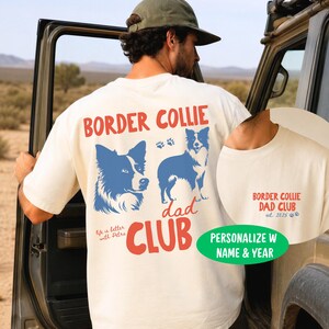 May include: An ivory t-shirt featuring a graphic on the back with the text BORDER COLLIE DAD CLUB in red, blue illustrations of a border collie, and paw prints. The front chest area displays the text BORDER COLLIE DAD CLUB est. 2025.