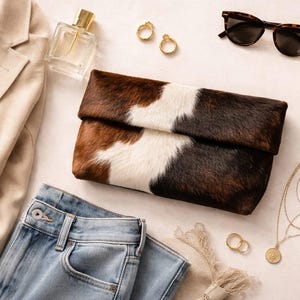 Handcrafted large leather clutch bag made from genuine tri-color hair-on-hide cowhide, featuring a modern foldover design in natural brown, black, and white tones for a western boho aesthetic. gift for her, gift for sister, gift for mother, personalized gift, custom handmade gift, trendy fashion