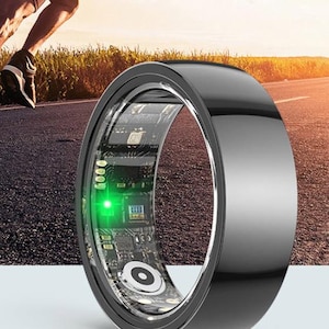 May include: A black smart ring with a clear inner band displaying circuit board components and a green light. The ring is shown with a runner in the background, suggesting fitness tracking capabilities. The ring has a sleek, modern design.