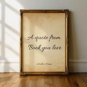 May include: A rectangular wall art print encased in an ornate, metallic gold frame. The print features a beige, parchment-style background with the black text "A quote from Book you love" and "-Author Name" centered in a classic serif font.