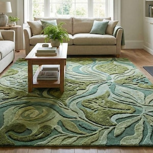 May include: A large area rug with a floral design in shades of green and teal dominates the living room. Two beige sofas and a wooden coffee table are also in the room. The rug's dimensions are approximately 8 x 10 feet.