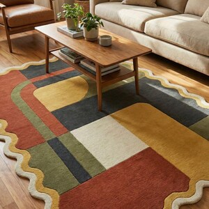 May include: A colorful, geometric area rug with a scalloped edge. The rug features a patchwork design with squares and rectangles in shades of red, yellow, green, and gray. A wooden coffee table and sofa are in the background.