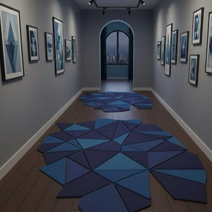 May include: A hallway with framed artwork and geometric rugs. The artwork features blue and white abstract designs. The rugs are composed of blue triangular shapes. The walls are gray, and the floor is wood.