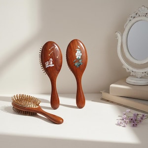 Puede incluir: Tres cepillos de pelo de madera con cerdas naturales. Dos cepillos tienen diseños pintados: un motivo floral y un diseño celestial. El tercer cepillo es de forma ovalada con un mango de madera y cerdas doradas.