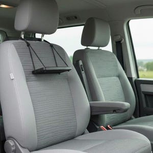 Può includere: Interno auto con sedili anteriori grigio chiaro. I sedili hanno tessuto strutturato al centro e lati lisci. Un vassoio nero, per tablet o dispositivo simile, è appeso al poggiatesta del sedile del conducente.