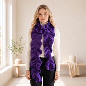 May include: A vibrant purple knitted scarf featuring a prominent ruffled texture along its entire length. The scarf is draped around the neck, showcasing a dense, intricate stitch pattern that creates a voluminous, wavy appearance in a deep violet hue.