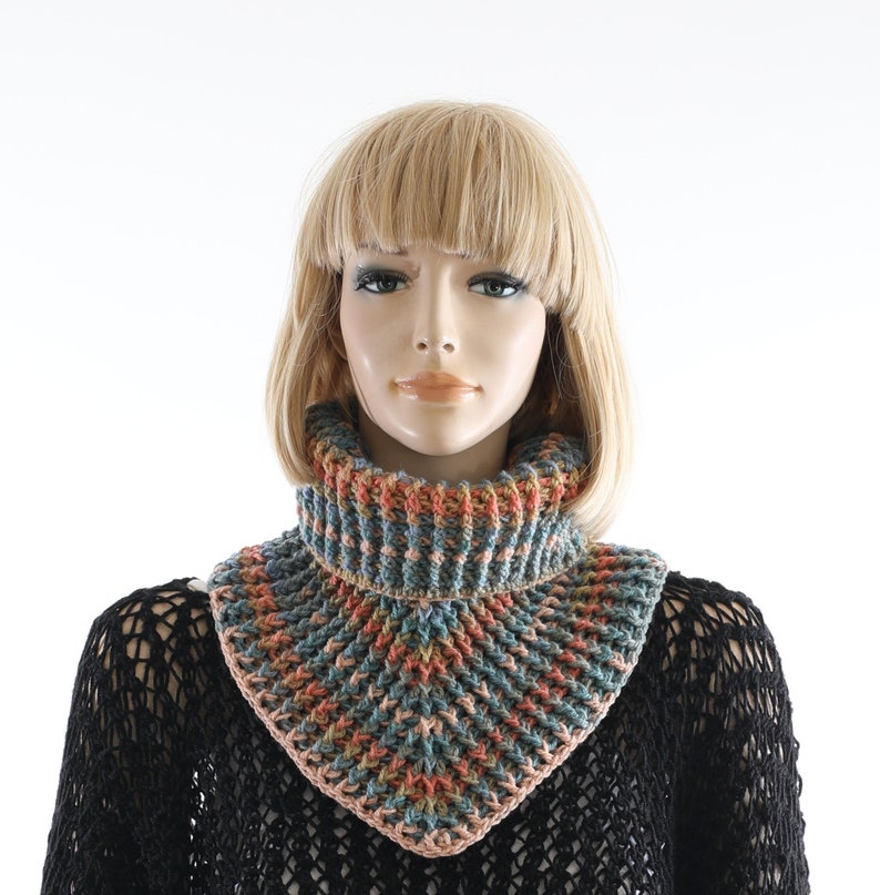 May include: A crocheted cowl with a multi-colored pattern in shades of blue, orange, and pink. The cowl is made of a soft yarn and has a comfortable fit.