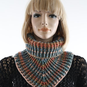 May include: A crocheted neck warmer in shades of blue, pink, orange, and brown. The neck warmer is made with a textured stitch and has a triangular shape.