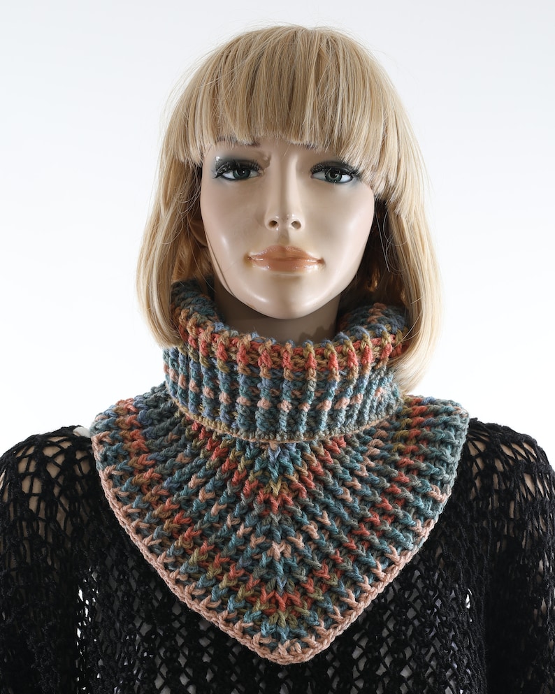 May include: A crocheted neck warmer in shades of blue, pink, orange, and brown. The neck warmer is made with a textured stitch and has a triangular shape.