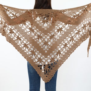 Peut inclure: Un châle en crochet marron avec un motif floral.