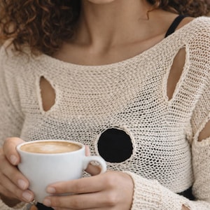 May include: A set of three ceramic mugs with a speckled, matte finish. The mugs are in shades of cream, light grey, and dark grey. Each mug has a simple, minimalist design, ideal for coffee or tea.