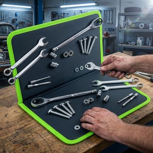 Peut inclure: Un tapis organisateur d'outils magnétique avec une bordure vert vif et une surface noire, contenant divers outils en métal argenté tels que des clés, des douilles, des boulons et des écrous, disposés sur un établi en bois.