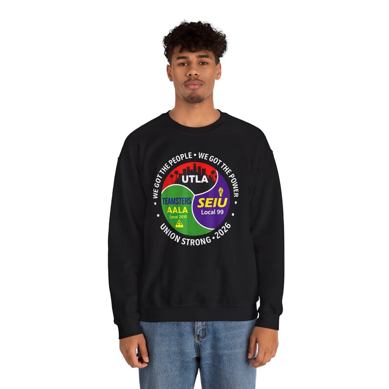 May include: Black sweatshirt with a circular graphic featuring the text "WE GOT THE PEOPLE" and "WE GOT THE POWER." The graphic includes the text "UTLA," "TEAMSTERS AALA Local 2010," and "SEIU Local 99." The words "UNION STRONG 2026" are also present.