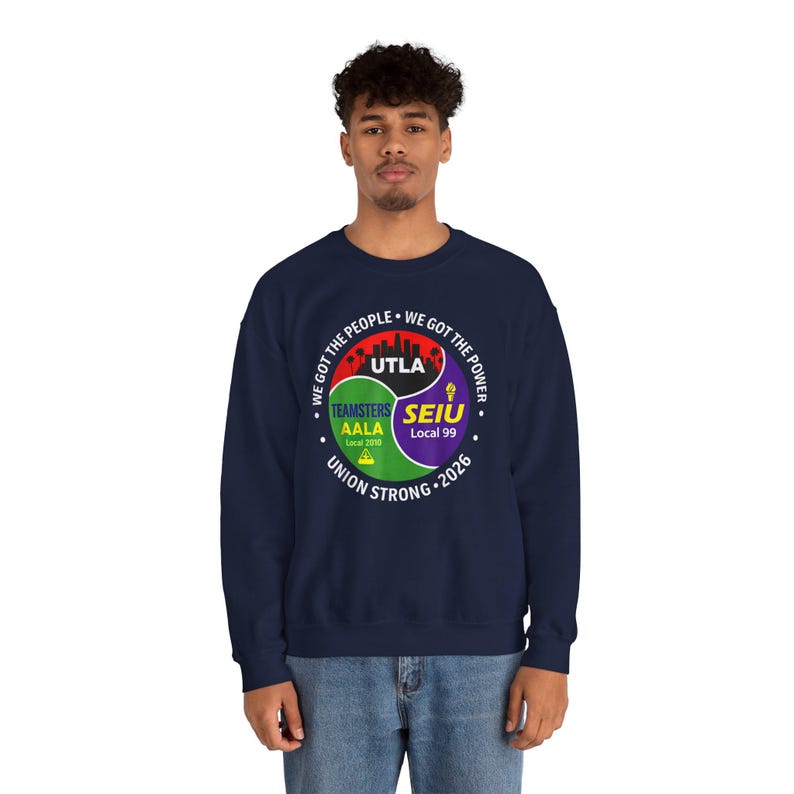 May include: Navy blue sweatshirt featuring a circular graphic with the text "WE GOT THE PEOPLE" and "WE GOT THE POWER". The graphic includes the text "UTLA", "TEAMSTERS AALA Local 2010", and "SEIU Local 99". The words "UNION STRONG 2026" are also present.