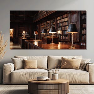 Puede incluir: Una gran impresión artística de pared que representa el interior de una biblioteca clásica. La imagen muestra estanterías de madera oscura llenas de libros, una larga mesa de madera con lámparas y un ambiente cálido y acogedor. La impresión se muestra sobre un sofá beige.